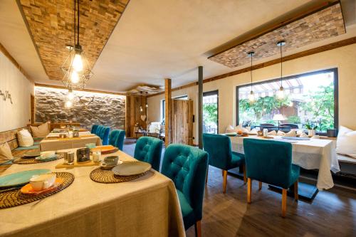 a dining room with tables and blue chairs at Gästehaus Richter in Grainau