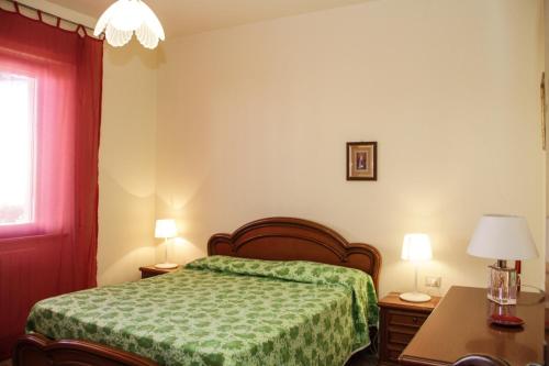 ein Schlafzimmer mit einem Bett, einem Tisch und zwei Lampen in der Unterkunft VIA FIRENZE in Marina di Castagneto Carducci