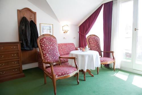 a dining room with three chairs and a table with at Hotel Grüner Baum in Bressanone