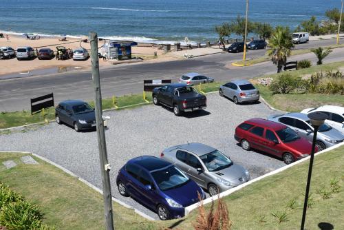 a group of cars parked in a parking lot near the beach at Apart Hotel Terrazas de San Francisco in Piriápolis
