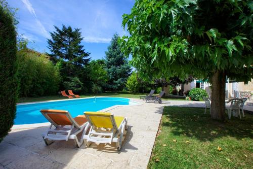 un groupe de chaises assises à côté d'une piscine dans l'établissement Les Abris de Saint Sulpice - Saint-Émilion, à Saint-Sulpice-de-Faleyrens