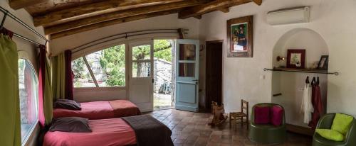 LanasにあるDomaine Les Princes, Mazet & sa Bergerieのベッドルーム1室(ベッド2台付)、窓付きのベッドルーム1室が備わります。