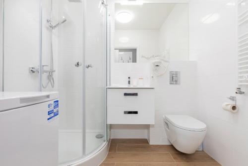 biała łazienka z prysznicem i toaletą w obiekcie Villa Ula Apartament w Pobierowie