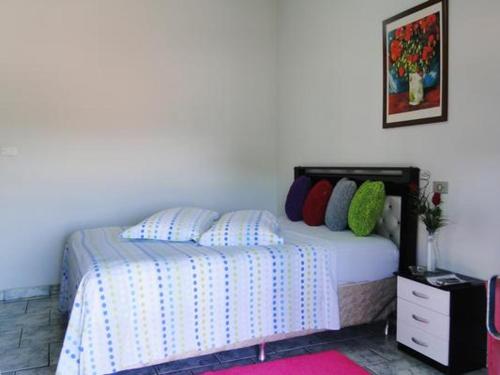 een slaapkamer met een bed en een dressoir met afkeer bij Pousada Israel in Pirenópolis