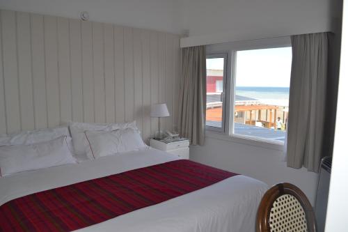 a bedroom with a bed and a large window at Club de Mar Terrazas Cayastá in Balneario Reta