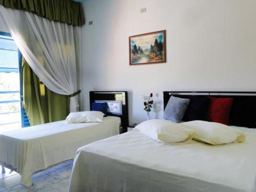 een hotelkamer met 2 bedden en een raam bij Pousada Israel in Pirenópolis