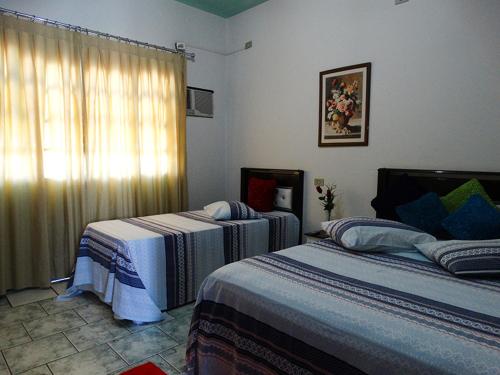 1 dormitorio con 2 camas y ventana en Pousada Israel, en Pirenópolis