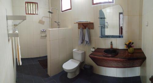 y baño con aseo y lavamanos. en New Raya - Nias Beach Bungalows, en Lagudri