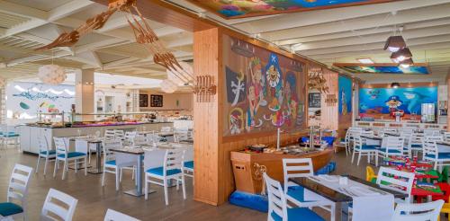 a dining room with white tables and chairs at H10 Suites Lanzarote Gardens in Costa Teguise