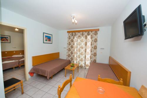 a living room with a couch and a bed and a television at Erato Studios & Apartments in Kos Town