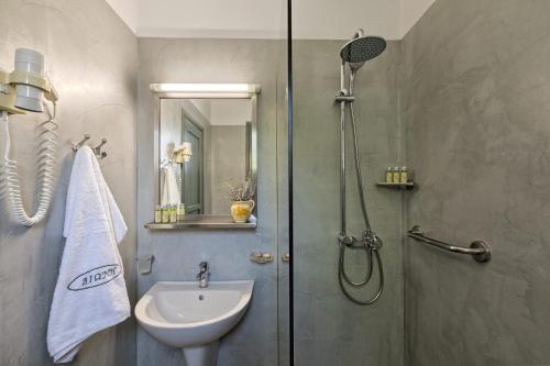 La salle de bains est pourvue d'une douche et d'un lavabo. dans l'établissement Dioni Hotel, à Skiros