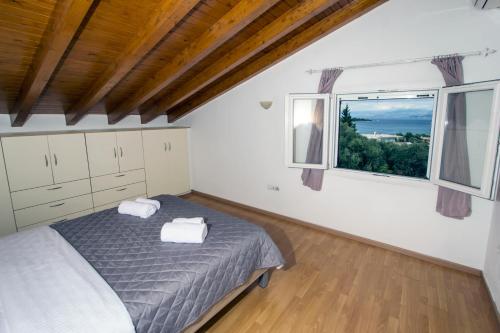 a bedroom with a bed and a large window at Corfu Villa Levanta in Kontokali