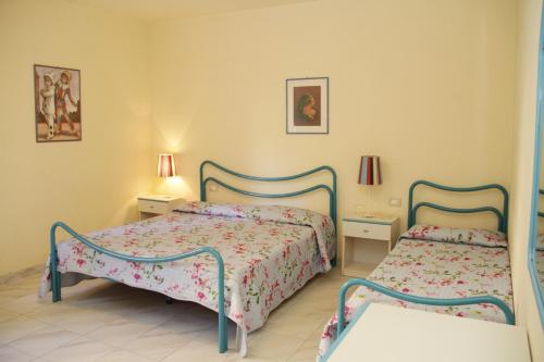 a bedroom with two beds and two lamps at VIA DELLA SOGLIOLA in Marina di Castagneto Carducci