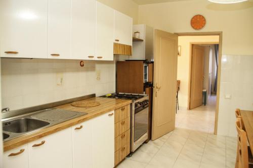 a kitchen with white cabinets and a sink and a stove at VIA DELLA SOGLIOLA in Marina di Castagneto Carducci