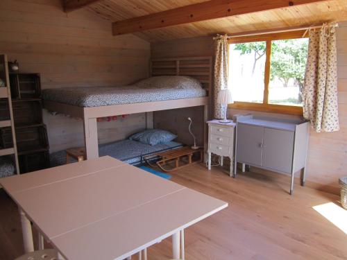 een kamer met een stapelbed en een tafel in een hut bij La Grange de Campaulise - Camping à la ferme - Hébergements - Mont Ventoux in Mazan
