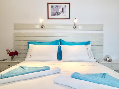a bed with blue and white pillows on it at Anna's Studio in Piso Livadi