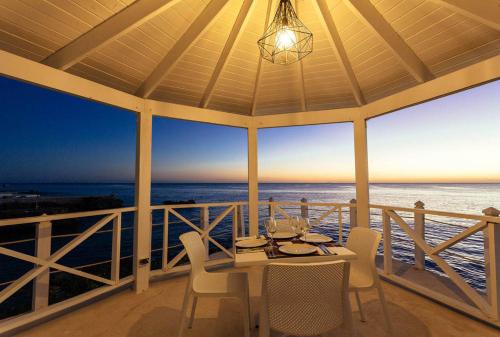 a porch with a table and chairs and the ocean at Habitacion en Sol Dominicus solo adultos in Bayahibe