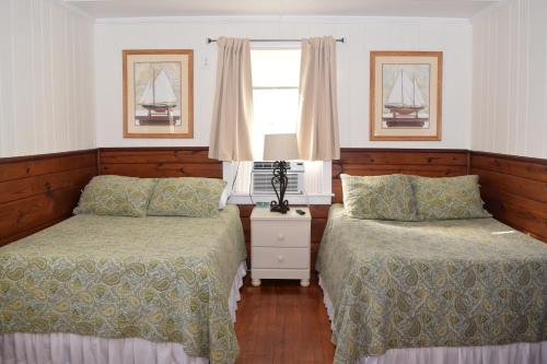 a bedroom with two beds and a window at Blackbeard's Lodge in Ocracoke