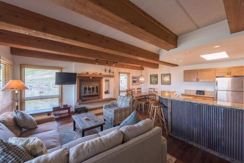 a living room with couches and a kitchen at The Plaza Condominiums by Crested Butte Mountain Resort in Mount Crested Butte