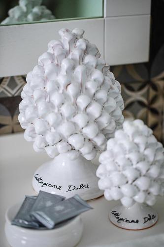 a white vase filled with white balls on a table at White Stylish Apartments 2 in Vico Equense