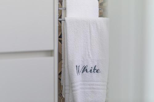 a white towel with the word whine written on it at White Stylish Apartments 2 in Vico Equense