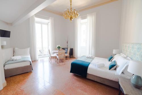 a bedroom with two beds and a chandelier at Boutique Hotel Atelier '800 in Rome