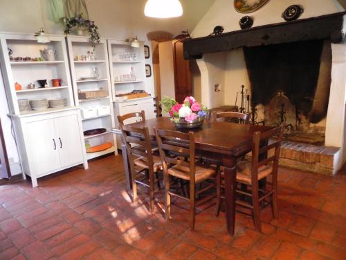 a dining room with a table and chairs and a fireplace at Agriturismo Le Ginestruzze in Montespertoli