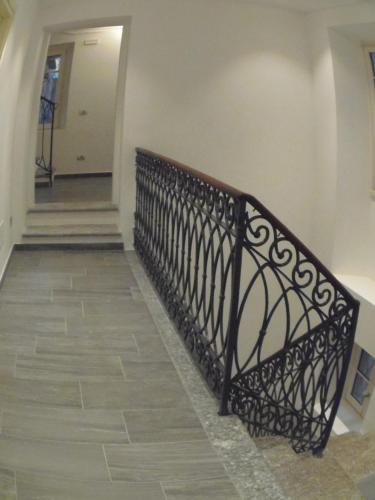a staircase with a black railing in a hallway at Albergo Dongo in Dongo