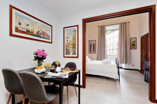 una camera da letto con tavolo e sedie di 4BNB - Cavour Square Apartment a Roma