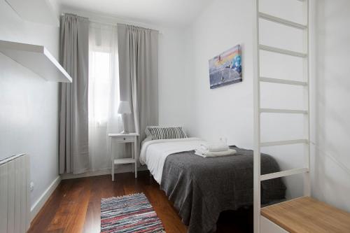 a small white bedroom with a bed and a window at Tendency Rambla del Poblenou in Barcelona