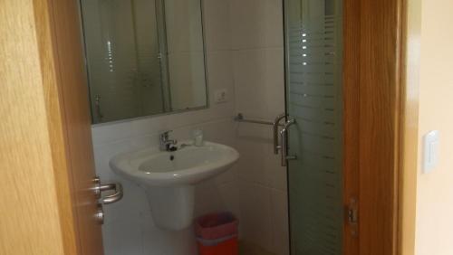 a bathroom with a sink and a mirror and a shower at Hostal-Meson Vilasante in Treacastela