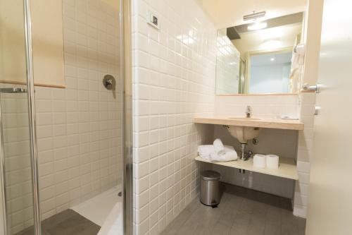 a bathroom with a shower and a sink and a mirror at Hotel Villa Moron in Negrar