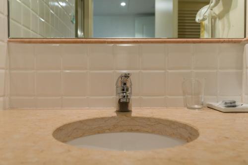 a bathroom sink with a faucet and a mirror at Hotel Villa Moron in Negrar