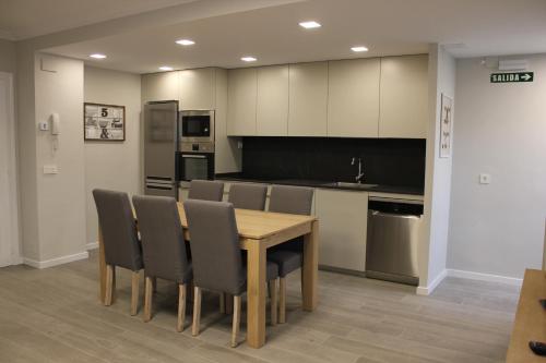 a dining room with a table and chairs and a kitchen at Apartamento Sanguesa in Sangüesa