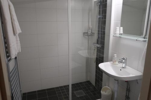 a bathroom with a shower, sink, and toilet at Hotel Aveny Bed & Breakfast in Gävle