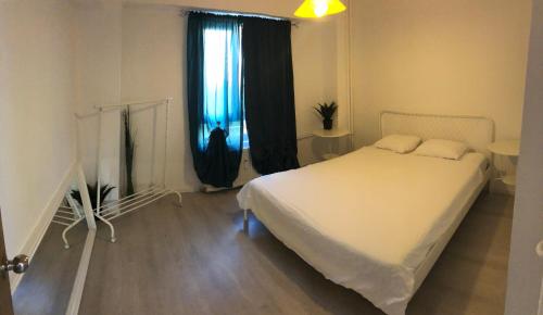 a bedroom with a white bed and a window at Green Apartment 59 in Bucharest