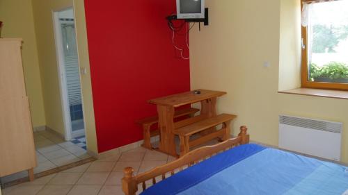 a room with a bed and a table in a room at La ferme Guibel in Plouzélambre