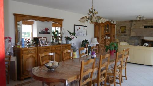 a dining room with a wooden table and chairs at La ferme Guibel in Plouzélambre