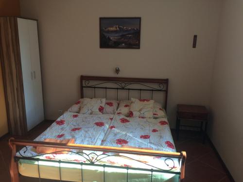 a bedroom with a bed with a floral comforter at Ubytovanie Emka in Hrabušice