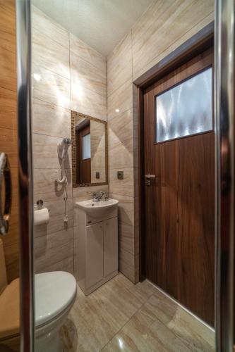 a bathroom with a toilet and a sink and a door at u kowola in Szaflary