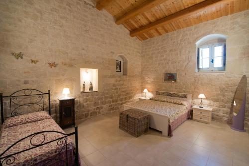 a bedroom with two beds and a window at Antica Masseria Adamo in Sampieri