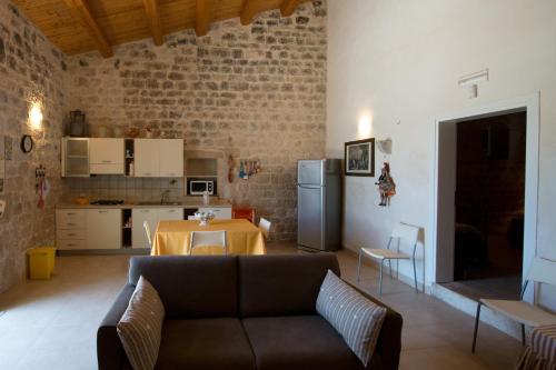 a living room with a couch and a kitchen at Antica Masseria Adamo in Sampieri