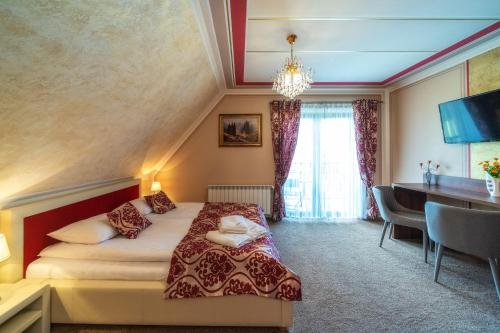 a hotel room with a bed and a desk at u kowola in Szaflary