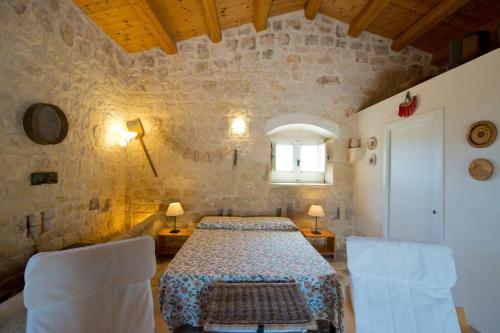 a bedroom with a bed and chairs in a room at Antica Masseria Adamo in Sampieri