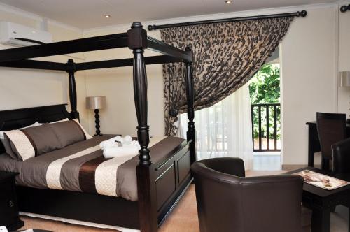 1 dormitorio con cama, escritorio y silla en Montana Boutique Guesthouse, en Pretoria