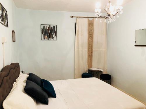 una camera con letto e lampadario a braccio di Una pausa tè per l'anima - Casa Vacanza a Cortona