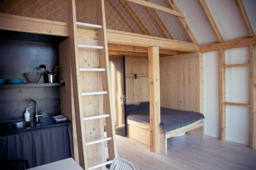 Peldmaja في بافيلوستا: غرفة نوم بسرير في غرفة خشبية