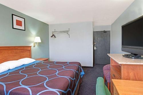 a hotel room with a bed and a flat screen tv at Super 8 by Wyndham Sacramento/Florin Rd in Sacramento