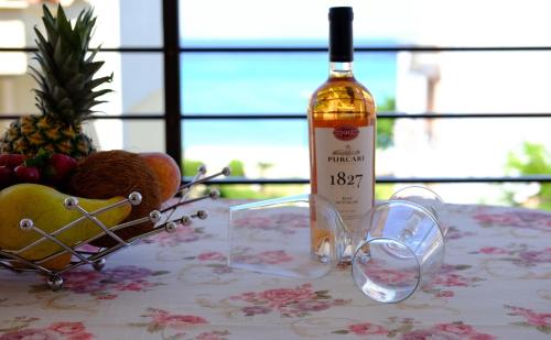 a bottle of wine sitting on a table with glasses at Apartments Alexandros in Polykhrono