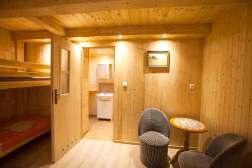 a wooden room with a bed and a table and chairs at Chatka u Dziadka in Szklarska Poręba